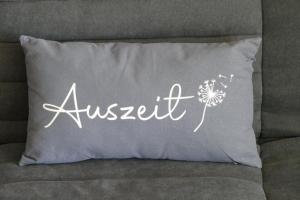 a pillow with the wordagent written on it on a couch at Ferienwohnung Geyersberg in Freyung