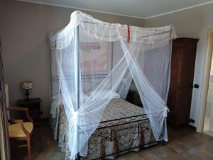 a bedroom with a bed with a mosquito net at La Terrazza del Barbaresco in Neviglie