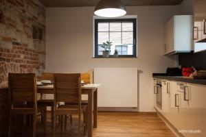 une cuisine avec une table et des chaises et une fenêtre dans l'établissement Ferienwohnungen - Alte Brauerei, à Rauhenebrach