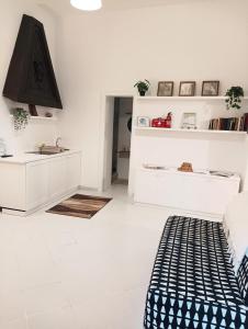 a white living room with a bed and a sink at Valerio's Flat in Pozzuoli