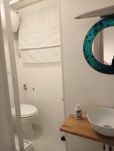 a bathroom with a toilet and a sink and a mirror at Valerio's Flat in Pozzuoli