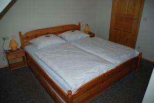 a bedroom with a wooden bed with two pillows at Ferienwohnung Lahnerhof in Arriach