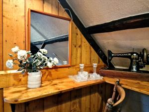 a wooden counter with a mirror and a vase of flowers at Y Cartws near Llangrannog in Llangrannog +37 photos