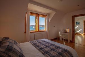 a bedroom with a bed and a window at Castlebay View in Castlebay