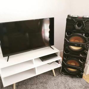 a flat screen tv sitting on a white entertainment center at Gite au Rocher in Chassiers