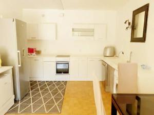 a kitchen with white cabinets and a sink at Gite au Rocher in Chassiers