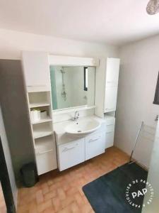 a white bathroom with a sink and a mirror at Gite au Rocher in Chassiers