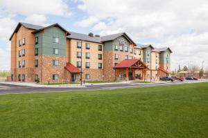 a large brick building with a green lawn in front of it at TownePlace Suites by Marriott Cheyenne Southwest/Downtown Area in Cheyenne