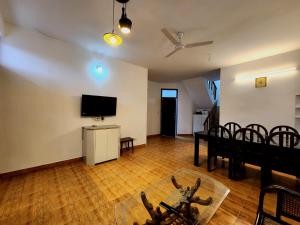 a living room with a flat screen tv and a table at Villa Kartina by the Hillstay in Bhowāli +23 photos