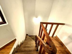 a staircase with a wooden railing and a light on the wall at Villa Kartina by the Hillstay in Bhowāli