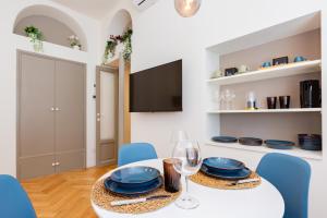une salle à manger avec une table blanche et des chaises bleues dans l'établissement CONFALONIERI21 Isola cozy apartment by Hospity, à Milan