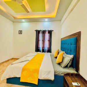 a bedroom with a large bed with a blue headboard at The Grey Villa - Private Pool in Calangute