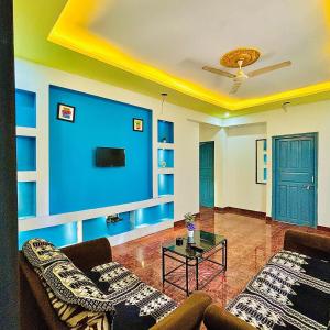 uma sala de estar com paredes azuis e um sofá e uma mesa em The Grey Villa - Private Pool em Calangute