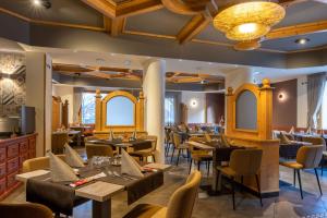 restauracja z drewnianymi sufitami, stołami i krzesłami w obiekcie Hotel Dolomiti Saone w mieście Tione di Trento
