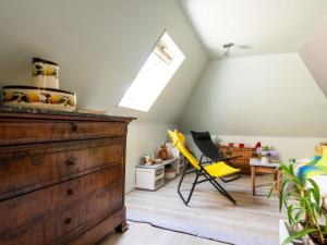 Zimmer im Dachgeschoss mit einer Kommode und einem gelben Stuhl in der Unterkunft Holiday Home Roucan by Interhome in Teyssieu