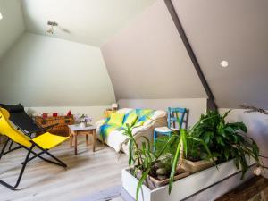 a room with a bed and a yellow chair and plants at Holiday Home Roucan by Interhome in Teyssieu
