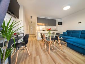 ein Wohnzimmer mit einem blauen Sofa, einem Tisch und Stühlen in der Unterkunft Apartment Gavun by Interhome in Bibinje