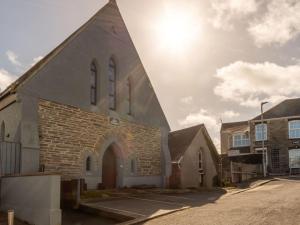 a church with a tall steeple on a street at Holiday Home Lobster by Interhome in Newquay