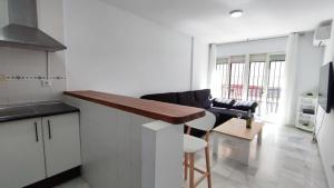 cocina y sala de estar con barra y mesa en Fantástico apartamento totalmente renovado, en Torre del Mar