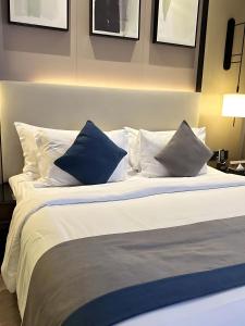a large bed with blue and white pillows at First Class Airport Hotel's With Free Transportation in Arnavutköy