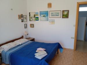 Un dormitorio con una cama azul con toallas. en Manolo s olive farm, apartment with seaview, en La Canea