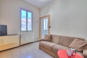 ein Wohnzimmer mit einem Sofa und einem TV in der Unterkunft Appartamento Gabriella - Happy Rentals in Laveno-Mombello