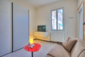 ein Wohnzimmer mit einem Sofa und einem roten Tisch in der Unterkunft Appartamento Gabriella - Happy Rentals in Laveno-Mombello