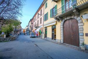 a street with a building with a large wooden door at Appartamento Gabriella - Happy Rentals in Laveno-Mombello