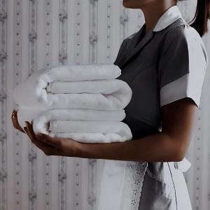 a woman holding a stack of white towels at First Class Airport Hotel's With Free Transportation in Arnavutköy
