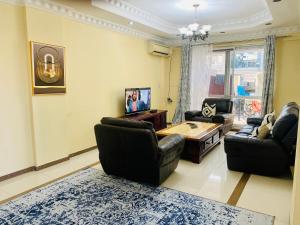 ein Wohnzimmer mit Sofas und einem Couchtisch in der Unterkunft Platinum apartment in Daressalam