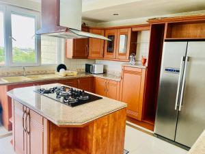 Platinum apartment في دار السلام: مطبخ مع دواليب خشبية وثلاجة حديد قابلة للصدأ