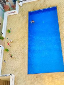 duży niebieski basen z ludźmi pływającymi w nim w obiekcie Platinum apartment w mieście Dar es Salaam