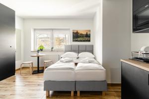 sypialnia z białym łóżkiem i kuchnią w obiekcie Apartamenty ZakoCHata Zakopane w Zakopanem