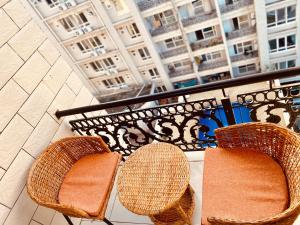 2 sillas de mimbre sentadas en un balcón con un edificio en Platinum apartment en Dar es Salaam