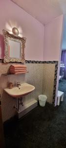 uma casa de banho com um lavatório e um espelho na parede em Hostel Kiezbude em Hamburgo