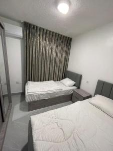 ein Hotelzimmer mit 2 Betten und einem Fenster in der Unterkunft شقق الريم in Ţāb Kirā‘