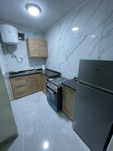 eine kleine Küche mit einem Herd und einem Kühlschrank in der Unterkunft شقق الريم in Ţāb Kirā‘