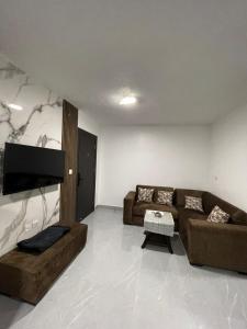 ein Wohnzimmer mit 2 Sofas und einem Flachbild-TV in der Unterkunft شقق الريم in Ţāb Kirā‘