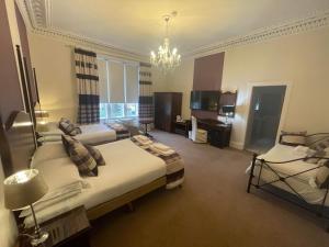 a large room with two beds and a chandelier at Avonbridge Hotel in Hamilton