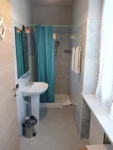 La salle de bains est pourvue d'un lavabo et d'une douche. dans l'établissement La Terrazza del Barbaresco, à Neviglie