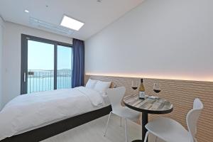 ein Hotelzimmer mit einem Bett und einem Tisch mit Weingläsern in der Unterkunft World Sky Residence Hotel in Sokcho
