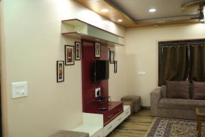 sala de estar con TV y sofá en Bagicha villa and cottage, en Mahabaleshwar