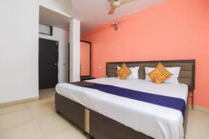 a bedroom with a large bed with an orange wall at Goroomgo Viren Pacific Agra Near Taj Mahal - Wonderfull Stay with Family in Agra