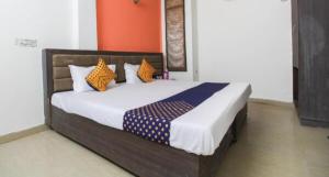 Goroomgo Viren Pacific Agra Near Taj Mahal - Wonderfull Stay with Family في آغْرا: غرفة نوم مع سرير مع وسائد برتقالية وزرقاء