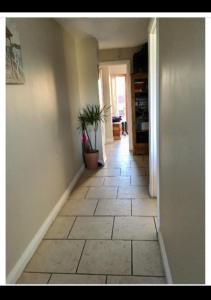 卡洛的住宿－Holiday house in quiet housing estate near Kilkenny，走廊上铺着瓷砖地板,种植了盆栽植物