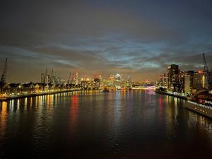 a view of a river with a city at night at Unique 2 bedroom apartment in London/ Excel / Olympic city close to central line tube station with gated parking space in London