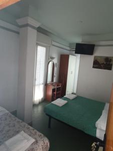 een kamer met 2 bedden, een tafel en een spiegel bij HOTEL AUGUSTUS in Gatteo a Mare
