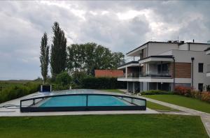 una casa con piscina di fronte a una casa di Coastline Balaton Apartment ad Alsóörs