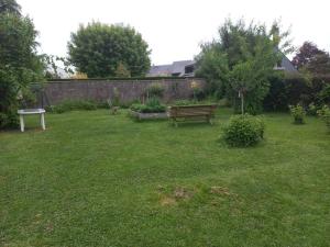un banco de parque en un patio con una valla en MAISON INDIVIDUELLE 110 M2-3 CHAMBRES-JARDIN 1000 M2 en Bois-Guillaume