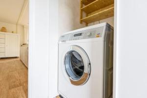 a white washer and dryer in a room at Prachtige vakantiewoning aan water met grote tuin in Voorthuizen